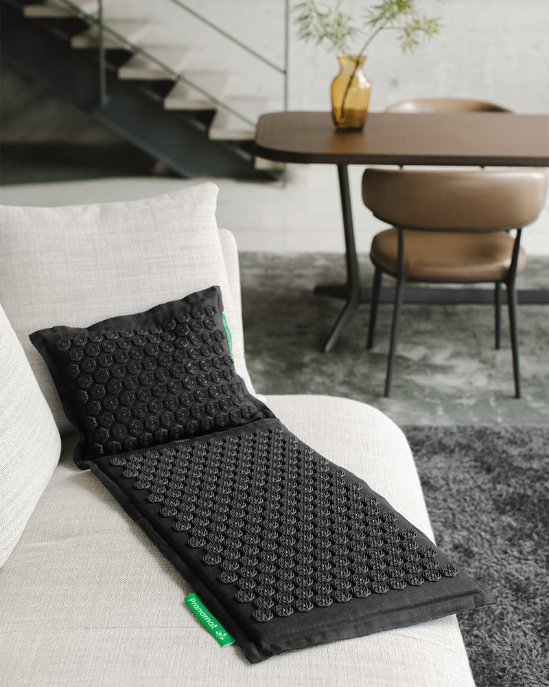 Black Pranamat set on a cream chair