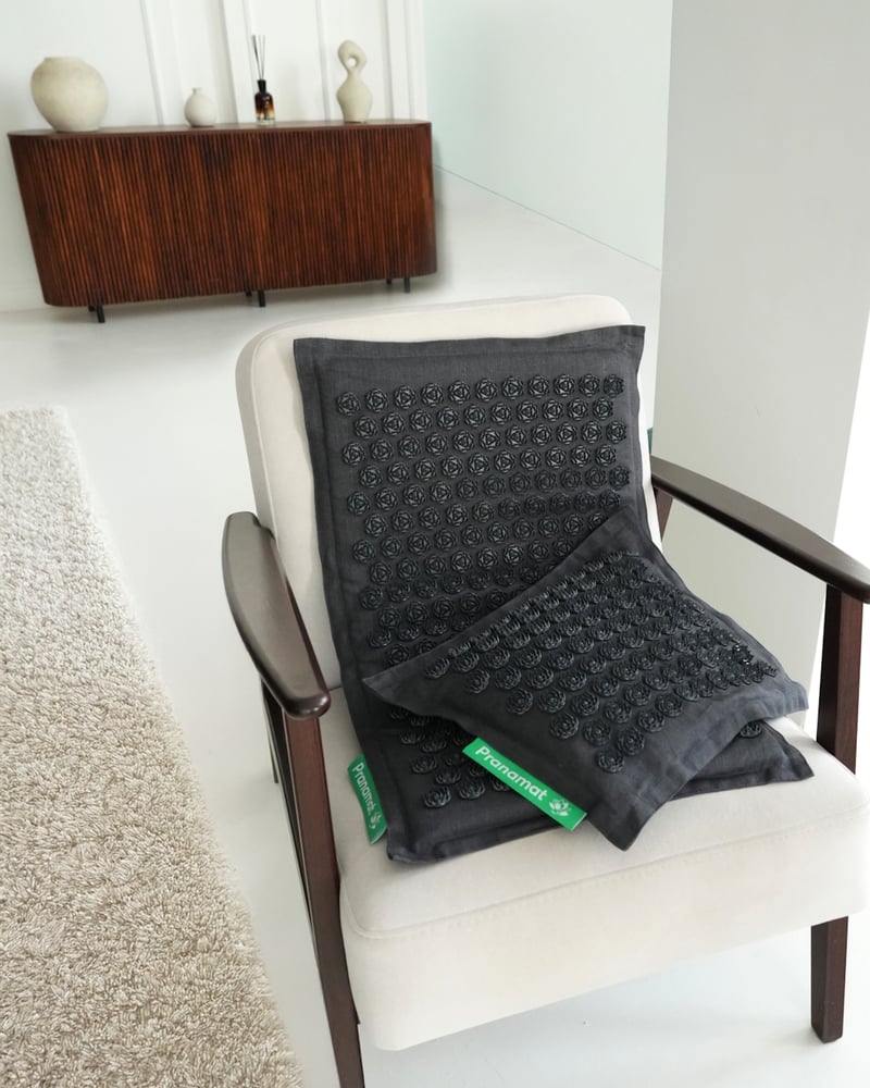 Graphite Pranamat set on a cream armchair