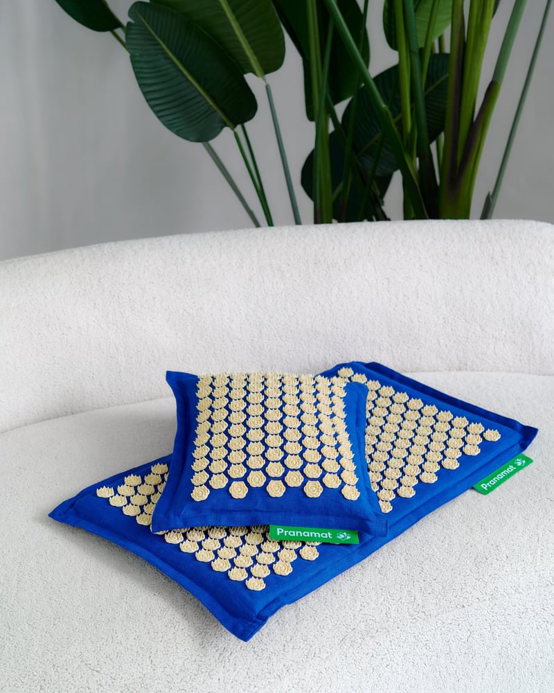 Blue and yellow Pranamat set on a white sofa